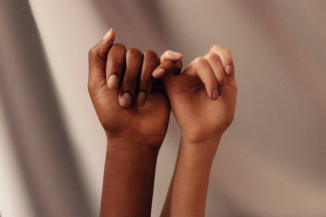 two hands with linked pinky fingers